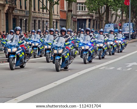 LILLE, FRANCE - JULY 14: A motorcycle unit of the French police riding in formation during a traditional Bastille Day parade through the city of Lille, France on July 14, 2012