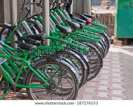 DELHI, INDIA - MARCH 29, 2014: Stand of bicycles for hire, one of various locations sited in a corridor for rapid transit buses in the city, designed to ease congestion and pollution from private cars