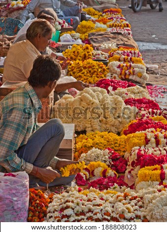 JAIPUR, INDIA - MARCH 25, 2014:  Traders selling flower garlands for use by worshippers in a nearby Hindu temple in the Tripolia Bazaar district of the old city