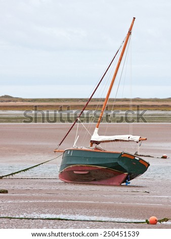 Stranded sailing boat at low tide on the river Torridge in Devon UK