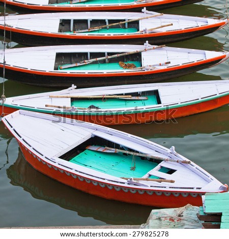 Part of a fleet of traditional pleasure boats for hire moored on the banks of the river Ganges at Varanasi, India