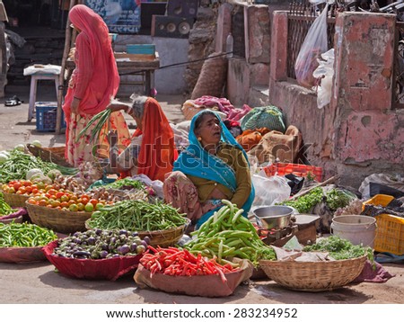 DEOGARH, INDIA - MARCH 8, 2015: Unidentified women selling fruit and vegetables at the roadside in the Rajasthani town. Many people bring produce from their small farms to sell in nearby urban areas