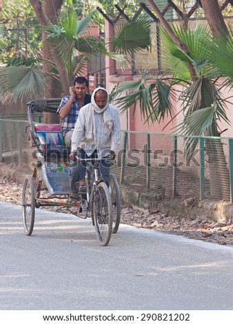 VARANASI, INDIA - MARCH 4, 2015: A cycle rickshaw transports a passenger in the centre of the city. This type of vehicle is extensively used by people to get around congested Indian cities