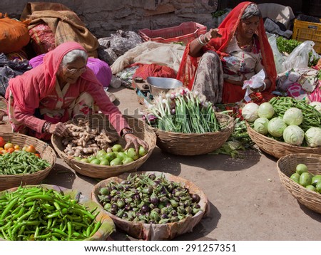 DEOGARH, INDIA - MARCH 8, 2015: Unidentified women selling fruit and vegetables at a roadside market in the town. Many local farmers bring their produce to the streets to sell to town dwellers