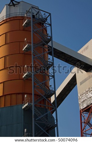 The clean lines and sharp angles of industrial conveyors and coal storage silos