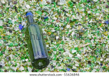 Wine bottle lying on a bed of broken glass having escaped the crusher at a  recycling facility in UK