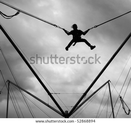 A shadow game, black and white photograph. We can see a child jumping with elastics.