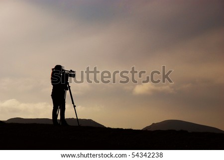 Yang lady is recording mountains landscape when sunset, memorizing fabulous colours and shadows from clouds and hills making a movie about nature of Atlantic Pyrenees