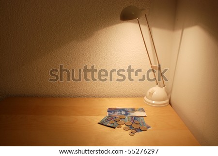 Swiss franc banknotes and coins at the bad table under the light of halogene lamp , just a part of the morden designe of the badroom