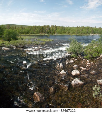 Its a fast stream of a river in finnish Lapland with larger flow surrounded by nordic forest at the background, this bautiful nordic landscape in summer time