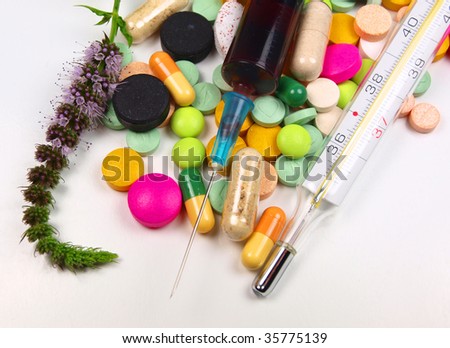 Pills with injection, thermometer and herb