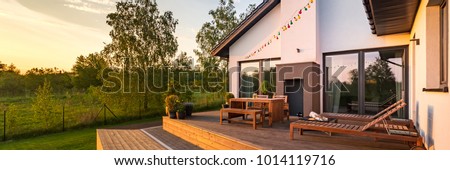 Modern house with patio and functional outdoor furniture, panorama