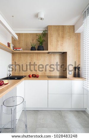 White, modern kitchen with wooden furniture and big window