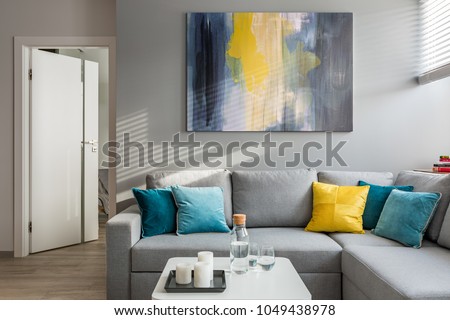 Living room with corner sofa, colorful cushions and white coffee table