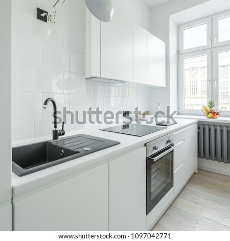 White kitchen with sink, worktop, simple cupboards and window
