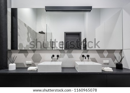 Minimalist bathroom in black, grey and white with two basins and big mirror
