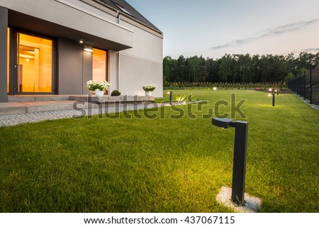 Image of modern villa with garden and decorative outdoor lighting, external view