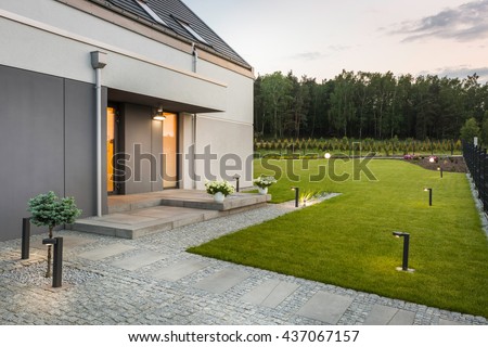 New villa with garden and decorative outdoor lighting, external view