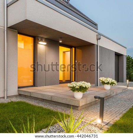 Modern house with nice lawn and surrounded by decorative outdoor lights