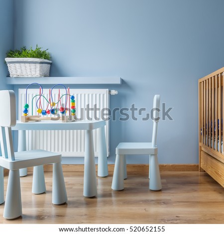 Blue baby room with small table, chairs and cot
