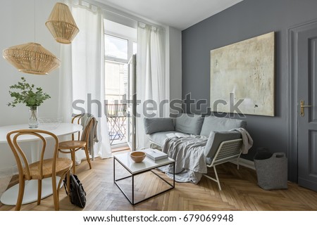 Gray living room with couch, table, modern painting and balcony