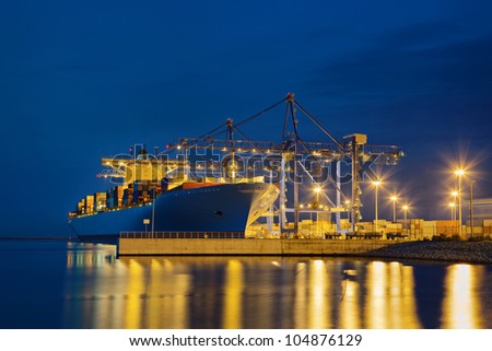 Large cargo ship on loading in the port at night.