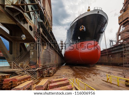 A large tanker ship is being renovated in shipyard Gdansk, Poland.