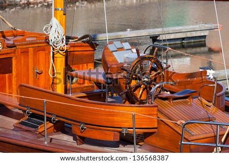 Captains steering wheel on wooden yacht.