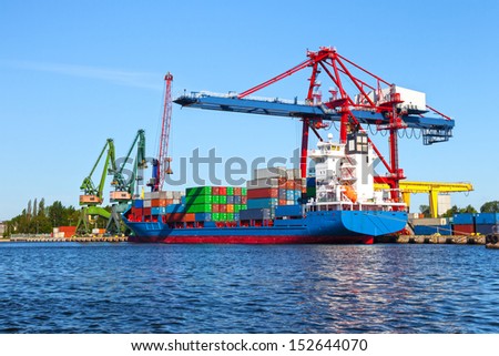 Seaport crane and huge container cargo ship ready for unloading.