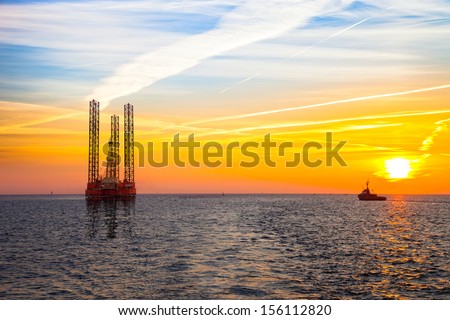 Oil rig at sunset background.