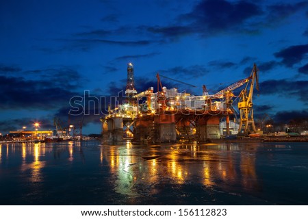 Oil rig at night in winter scenery.