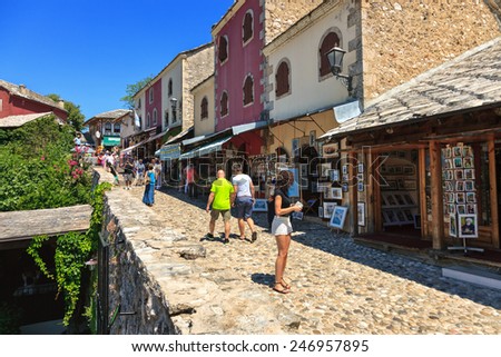 MOSTAR, BOSNIA AND HERZEGOVINA-JULY 20 : People walking through the Old Town with many shops and cafes on July 20, 2014 in Mostar, Bosnia and Herzegovina. Mostar is situated on the Neretva River.