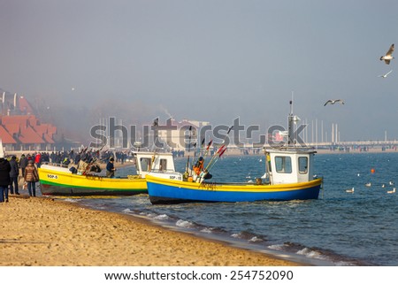 SOPOT, POLAND - FEBRUARY 14: Baltic coast beach scene of many people walk, relaxing and enjoying the shore in Valentines Day, on February 14, 2015 in Sopot, Poland.