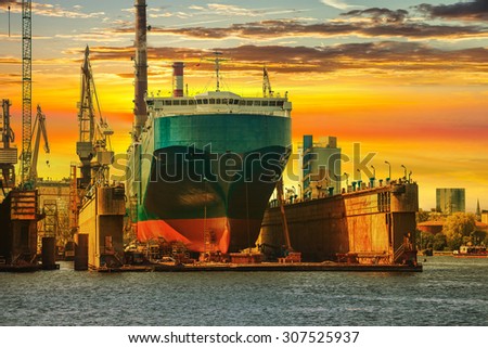 Ship being repaired in dry dock at sunset in Gdansk, Poland.