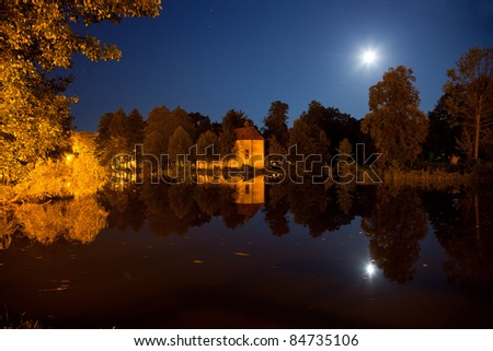 Church on the water at night in Zwierzyniec, Poland.