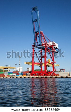 Gantry cranes in a harbor on a background of the blue sky.