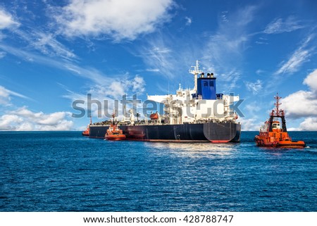 Tugboat towing a tanker ship at sea.