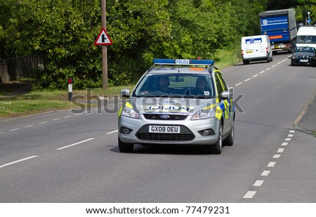 EAST GRINSTEAD, ENGLAND - MAY 15:  Police Car drives along A22 in Sussex during the East Grinstead Triathlon on May 15 2011. The Police play a valuable role in keeping the roads safe for cyclists.