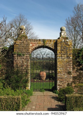 Arched Gate in old brick wall with blue sky
