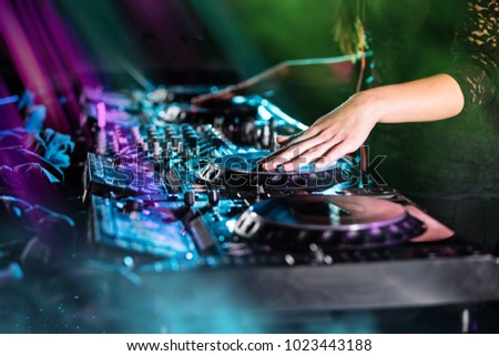 Dj mixes the track in the nightclub at a party, close-up.