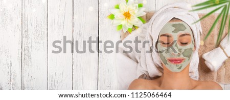 Young healthy woman in spa making treatments and face mask.