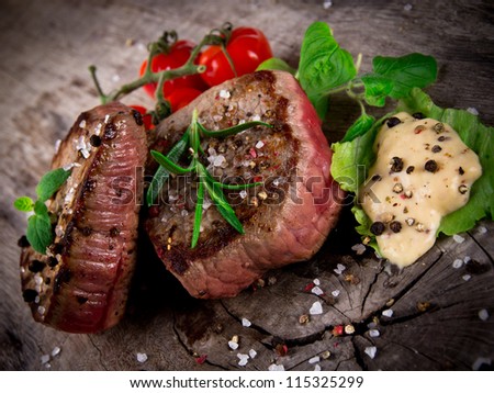 Medium grilled bbq steaks with fresh herbs and tomatoes