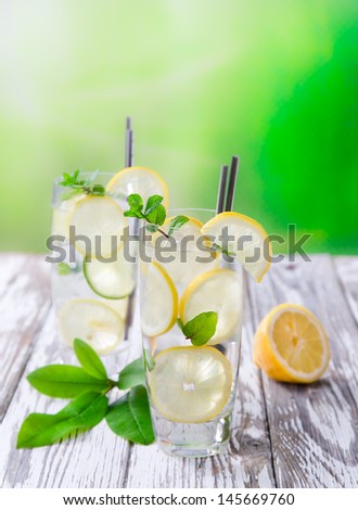 Cocktail with ice and lemon slices isolated on white background