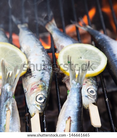 Fish on grill with lime slices and olive oil