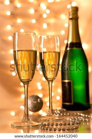 Pair of champagne flutes over gold background