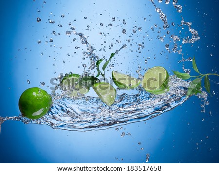 Limes with water splash isolated on white