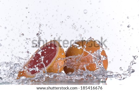 Grapefruit with water splash isolated on white