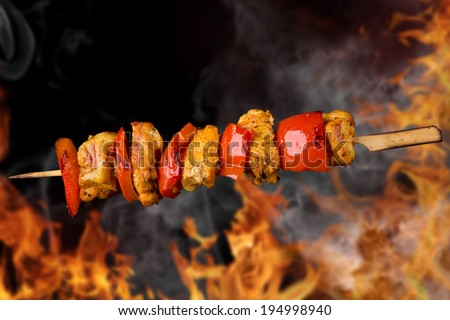 Tasty skewers with fire flames, close-up.