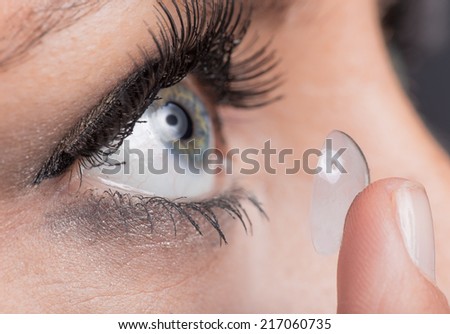 Young woman Inserting a contact lens, close-up