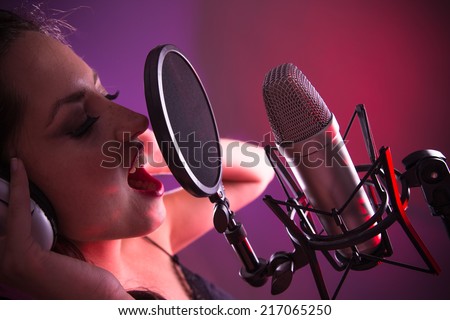 Young singer singing on the studio microphone